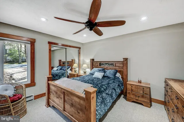 a bedroom with a bed and a dresser with mirror