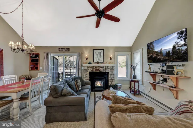 a kitchen with stainless steel appliances granite countertop a sink a stove and chairs with wooden floor