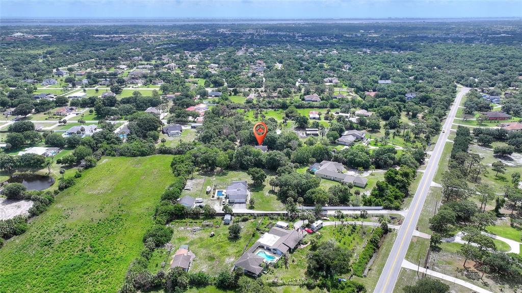 3641 Turtle Mound Road Melbourne, FL 32934 - Photo 72 of 77 an aerial view of a houses with a yard and lake
