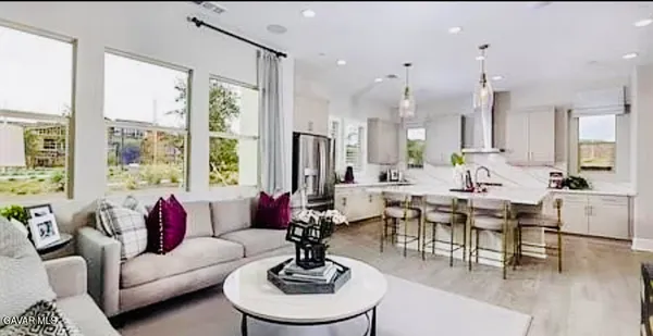 a living room with furniture large window and chairs