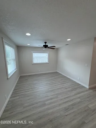 a living room with stainless steel appliances kitchen island a refrigerator wooden floor and a fireplace