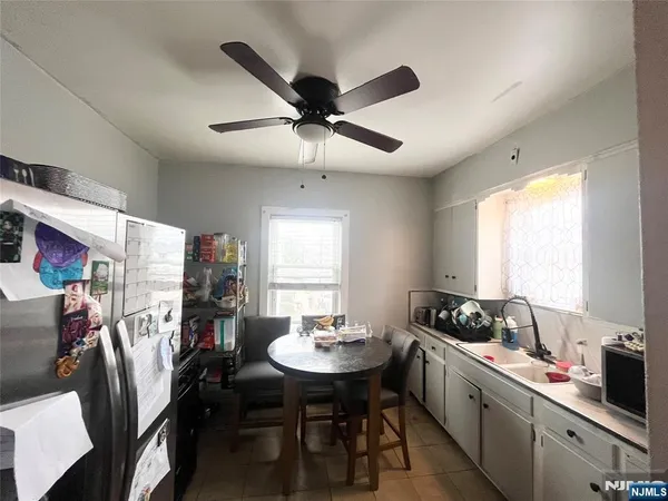 a kitchen with a dining table chairs sink and cabinets