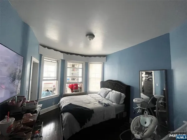 a bedroom with a bed and a large mirror with window