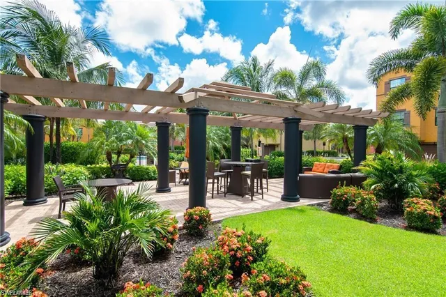 a view of a patio with table and chairs potted plants and large tree