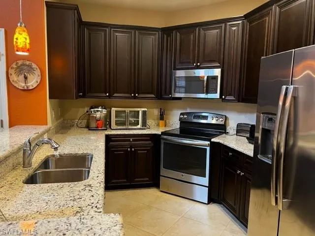 a kitchen with granite countertop wooden cabinets and stainless steel appliances