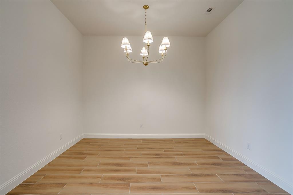 7286 Velvetleaf Street Benbrook, TX 76126 - Photo 14 of 39 a view of a room with wooden floor and a ceiling fan