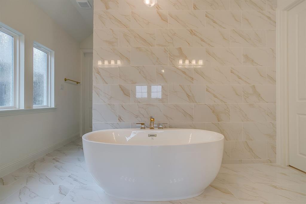 7286 Velvetleaf Street Benbrook, TX 76126 - Photo 29 of 39 a white bath tub sitting in a bathroom