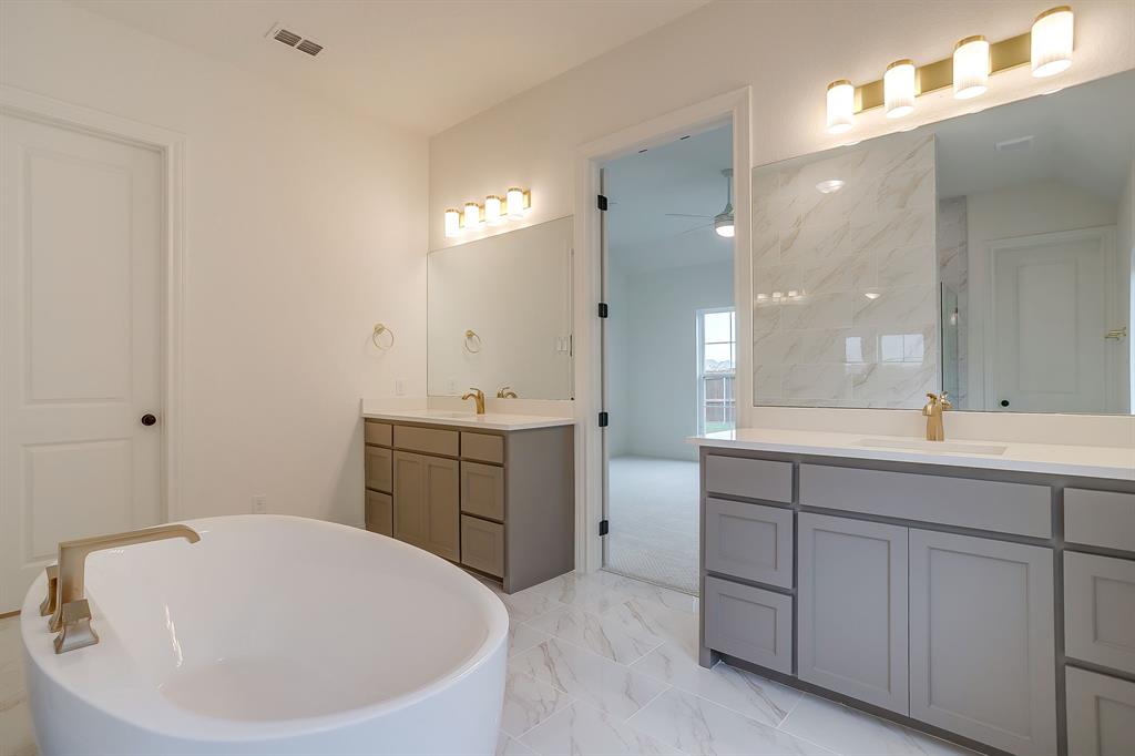 7286 Velvetleaf Street Benbrook, TX 76126 - Photo 31 of 39 a bathroom with a tub a sink and mirror