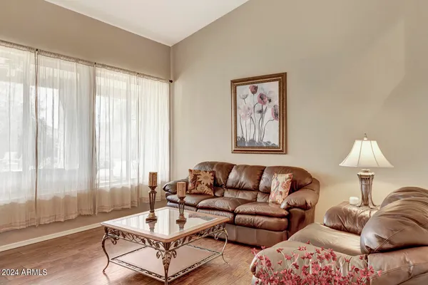 a living room with furniture a large window and a chandelier