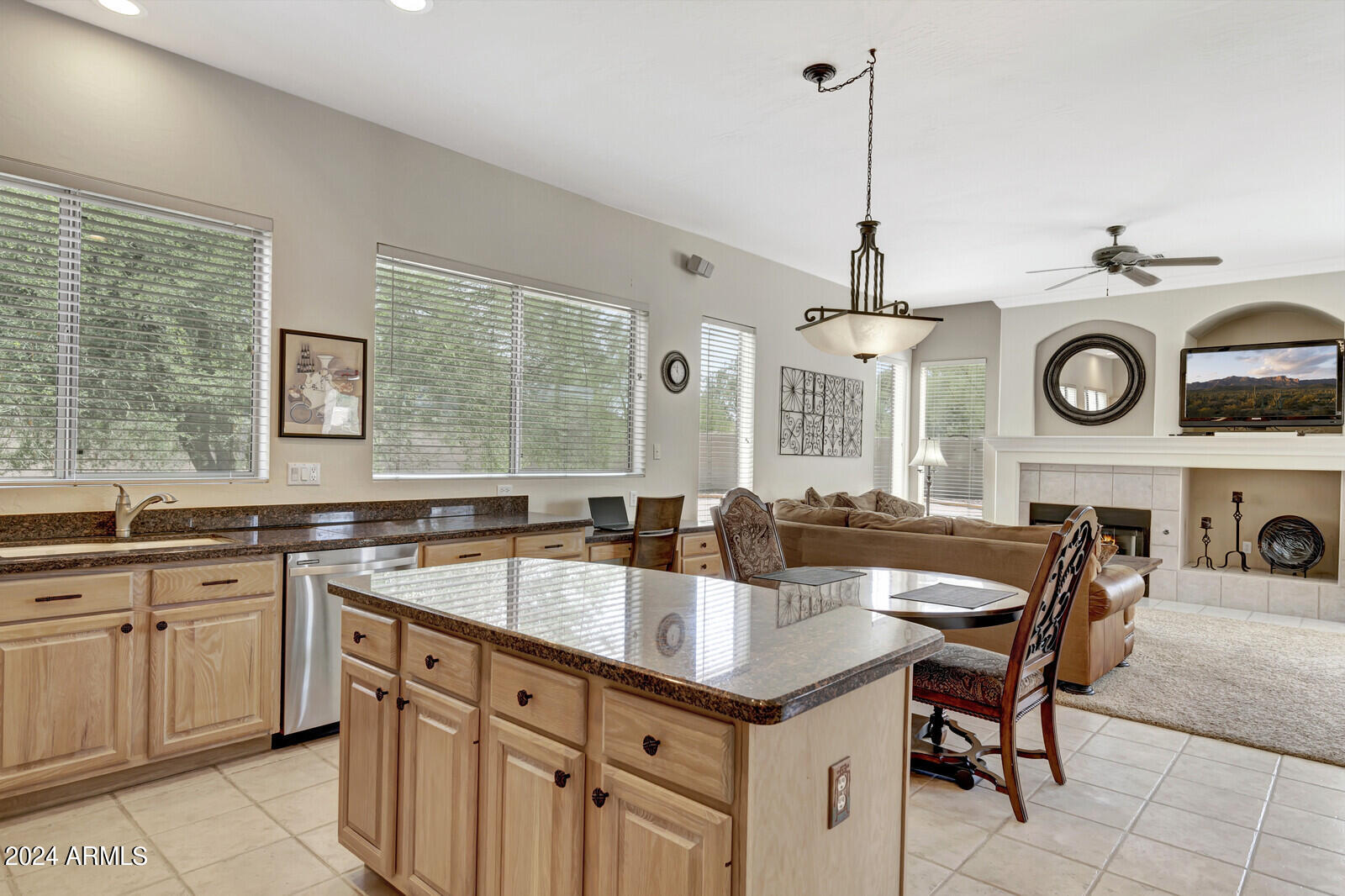 4343 East Mossman Drive Phoenix, AZ 85050 - Photo 8 of 36 a kitchen with kitchen island granite countertop a sink a stove a dining table and chairs