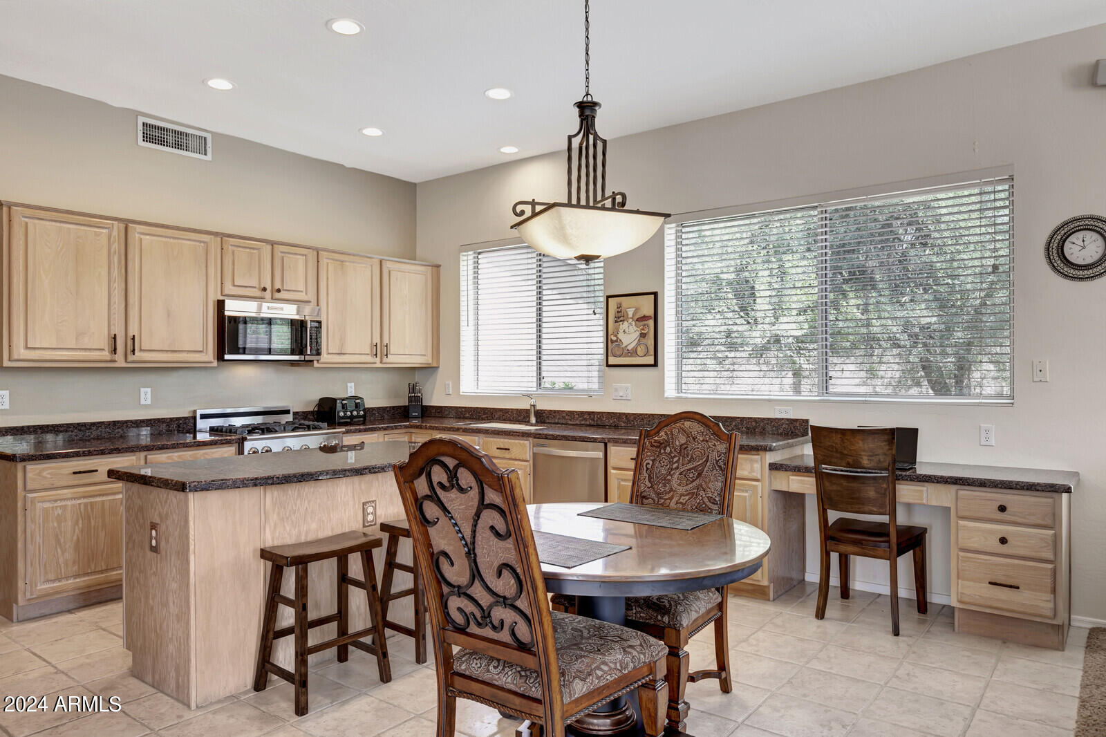 4343 East Mossman Drive Phoenix, AZ 85050 - Photo 9 of 36 a kitchen with granite countertop a stove a sink a dining table and chairs