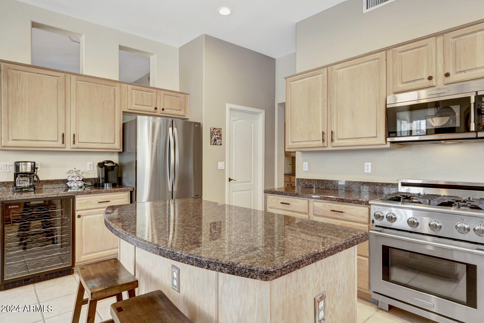 4343 East Mossman Drive Phoenix, AZ 85050 - Photo 10 of 36 a kitchen with stainless steel appliances granite countertop a stove a refrigerator a sink dishwasher and white cabinets next to a window