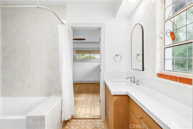 a bathroom with a tub sink and mirror