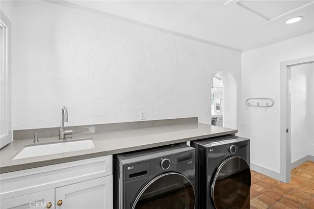 a utility room with sink dryer and washer