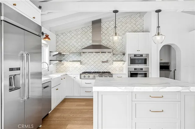 a kitchen with stainless steel appliances granite countertop a sink and a refrigerator