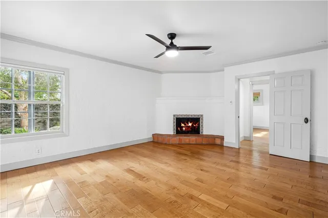 a view of an empty room with a fireplace and a window