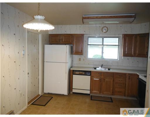 804 Pompton Road Monroe Township, NJ 08831 - Photo 10 of 12 a kitchen with a sink a refrigerator and cabinets