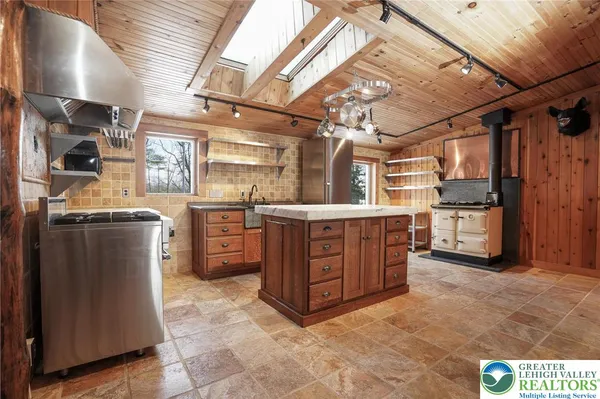 a kitchen with stainless steel appliances granite countertop a sink a stove and a wooden cabinets