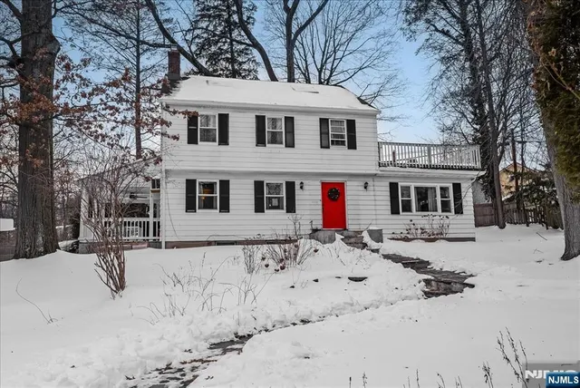 a front view of a house with a yard covered in snow
