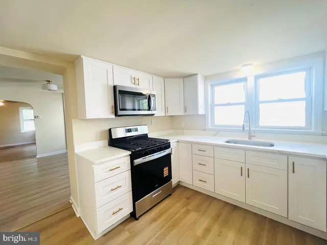 a kitchen with stainless steel appliances a stove sink and microwave
