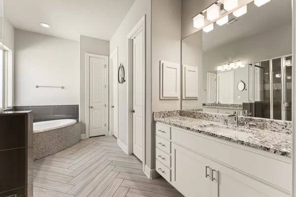 a bathroom with a granite countertop sink mirror and a bathtub