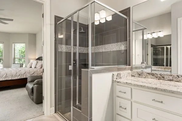 a bathroom with a granite countertop sink and shower