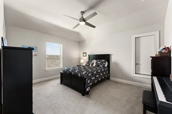 a bedroom with a bed window and a desk