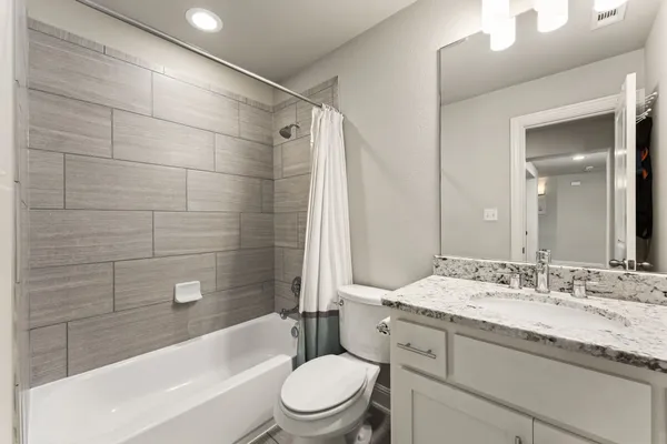 a bathroom with a granite countertop toilet a sink and bathtub