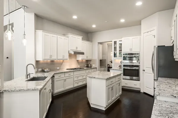a kitchen with a sink stove cabinets and refrigerator
