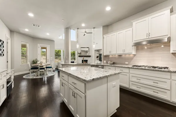 a kitchen with stainless steel appliances granite countertop a lot of counter space and wooden floor