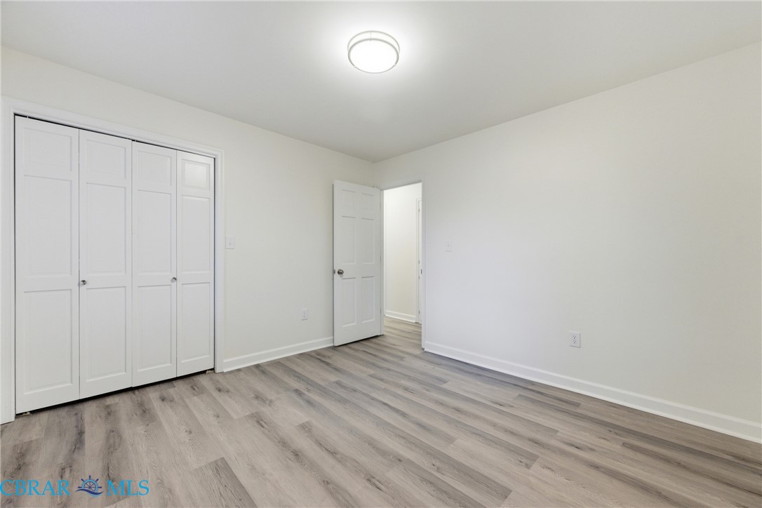 718 Dandy Loop Road Yorktown, VA 23692 - Photo 17 of 42 Unfurnished bedroom with light wood-type flooring and a closet
