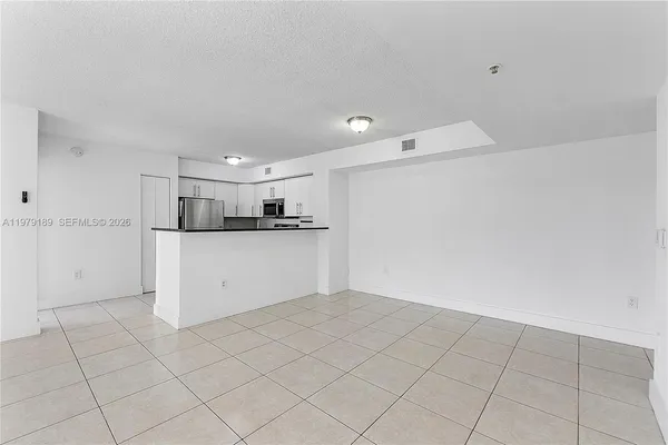 an empty room with a ceiling fan and window