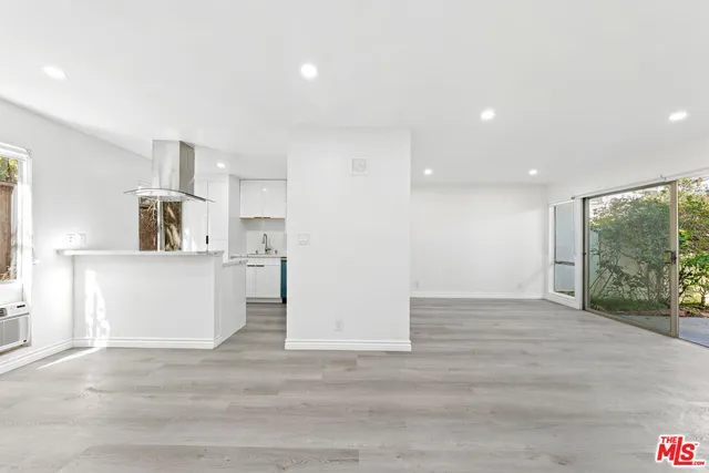 a view of a kitchen with kitchen island a sink wooden floor and a refrigerator