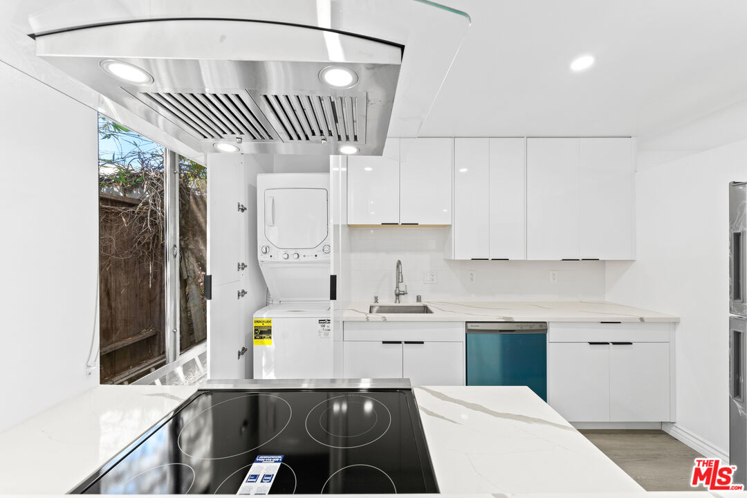 825 16th Street, Unit B Santa Monica, CA 90403 - Photo 4 of 15 a kitchen with stainless steel appliances a white stove top oven a sink dishwasher and white cabinets