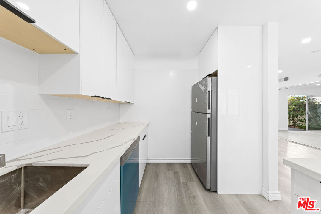 825 16th Street, Unit B Santa Monica, CA 90403 - Photo 5 of 15 a kitchen with white cabinets and a sink