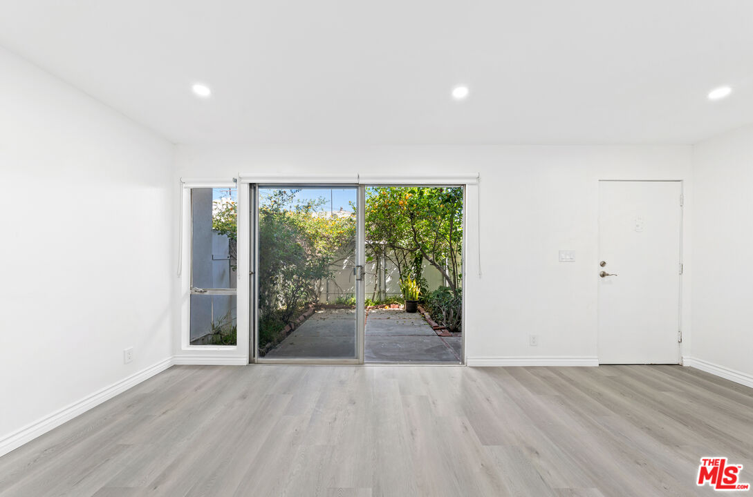 825 16th Street, Unit B Santa Monica, CA 90403 - Photo 6 of 15 an empty room with wooden floor and windows