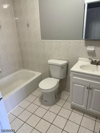 a bathroom with a toilet a sink a mirror and vanity