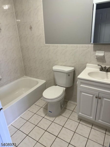 535 South 18th Street Newark, NJ 07103 - Photo 9 of 17 a bathroom with a toilet a sink a mirror and vanity