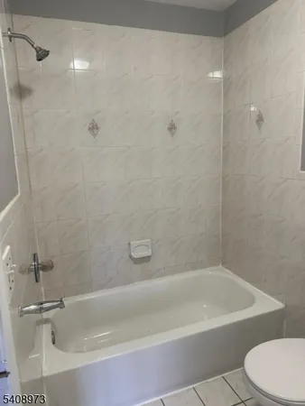 a white bath tub sitting next to a white toilet and a sink