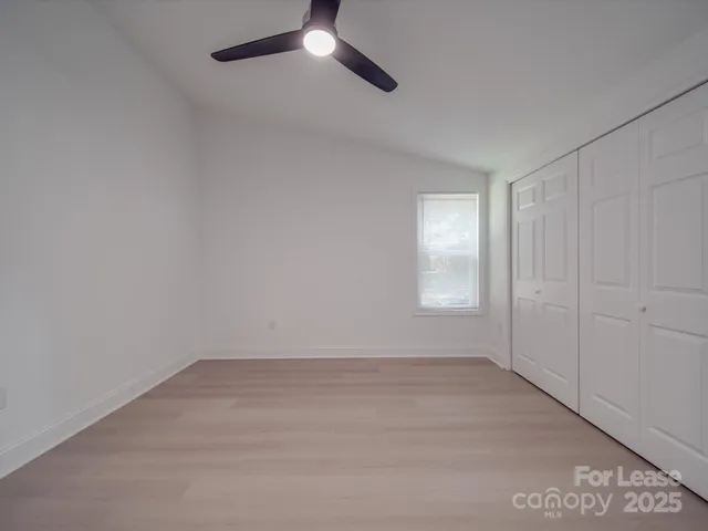 an empty room with windows and fireplace