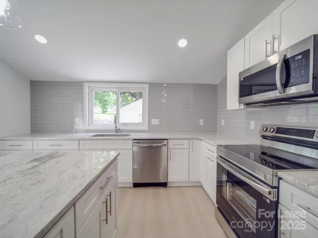 a kitchen with a sink chandelier and a stove