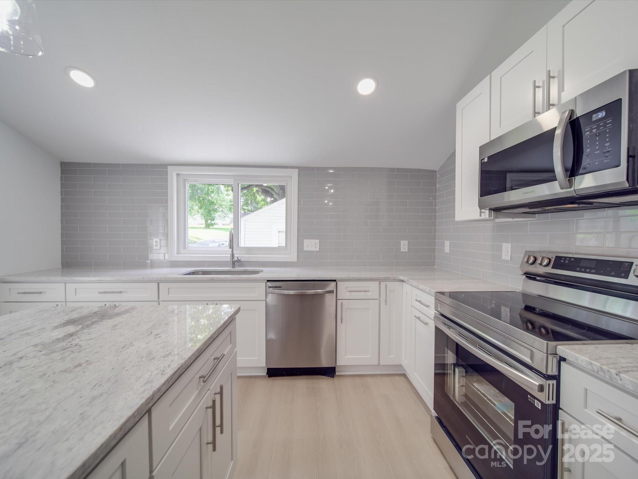 1012 Wood Street Albemarle, NC 28001 - Photo 19 of 31 a kitchen with stainless steel appliances granite countertop a stove a sink and a microwave