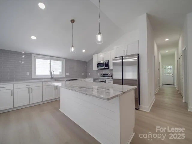 a view of a kitchen with a sink and refrigerator