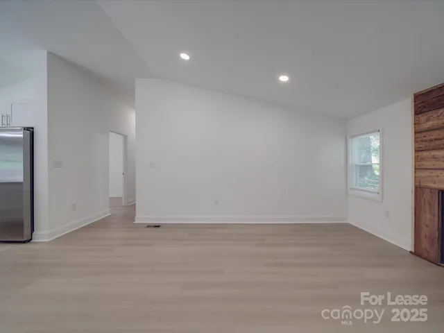 a view of empty room with a window and fireplace