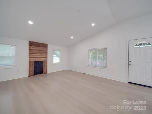 a view of an empty room with a fireplace and a window