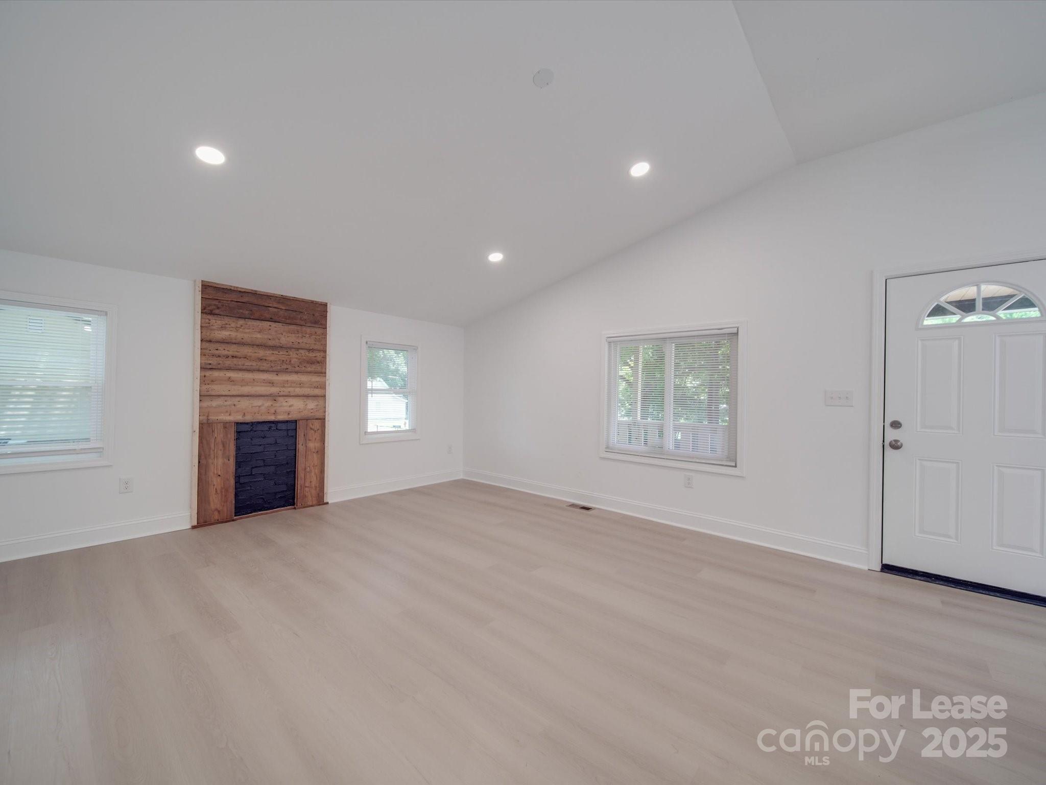 1012 Wood Street Albemarle, NC 28001 - Photo 5 of 31 a view of an empty room with a fireplace and a window