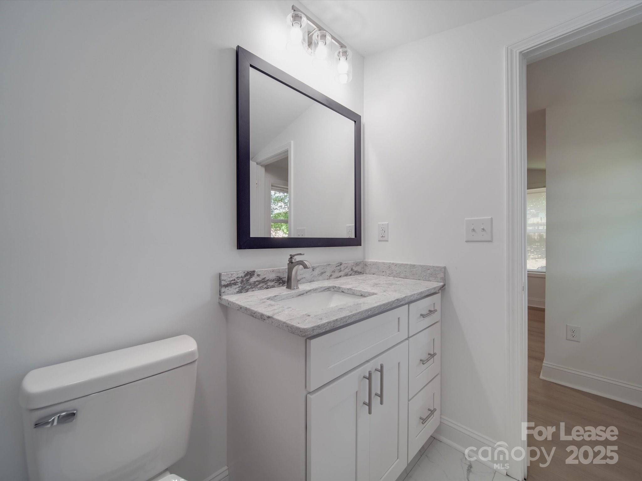 1012 Wood Street Albemarle, NC 28001 - Photo 6 of 31 a bathroom with a toilet sink and mirror