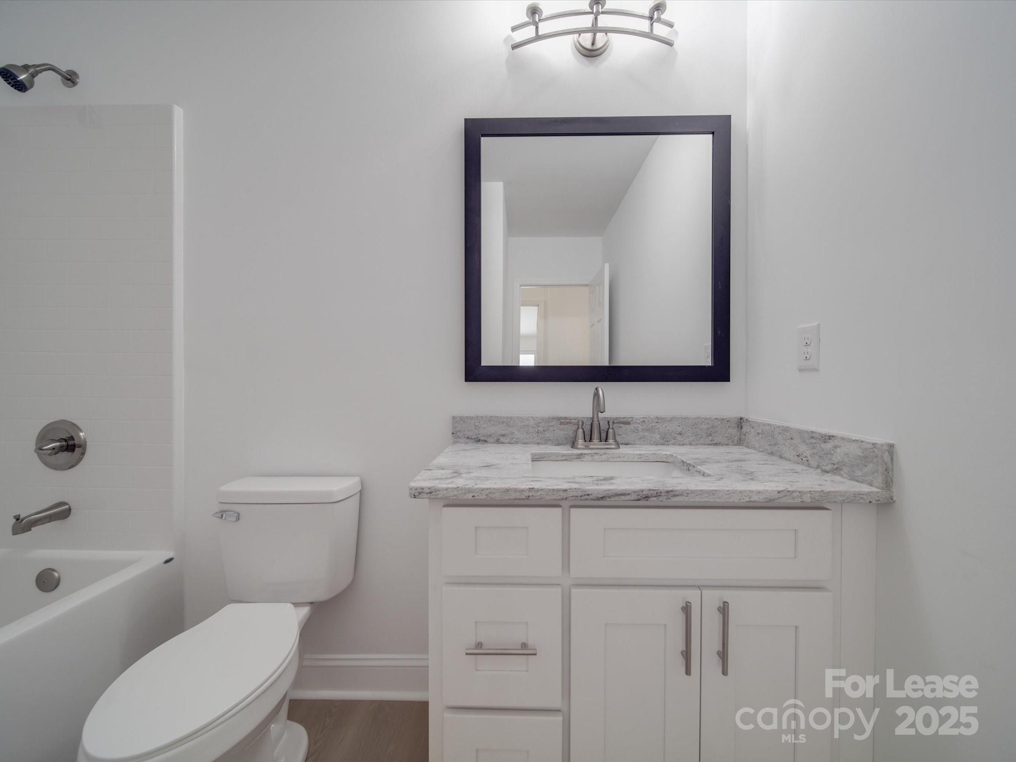 1012 Wood Street Albemarle, NC 28001 - Photo 10 of 31 a bathroom with a toilet sink vanity and mirror