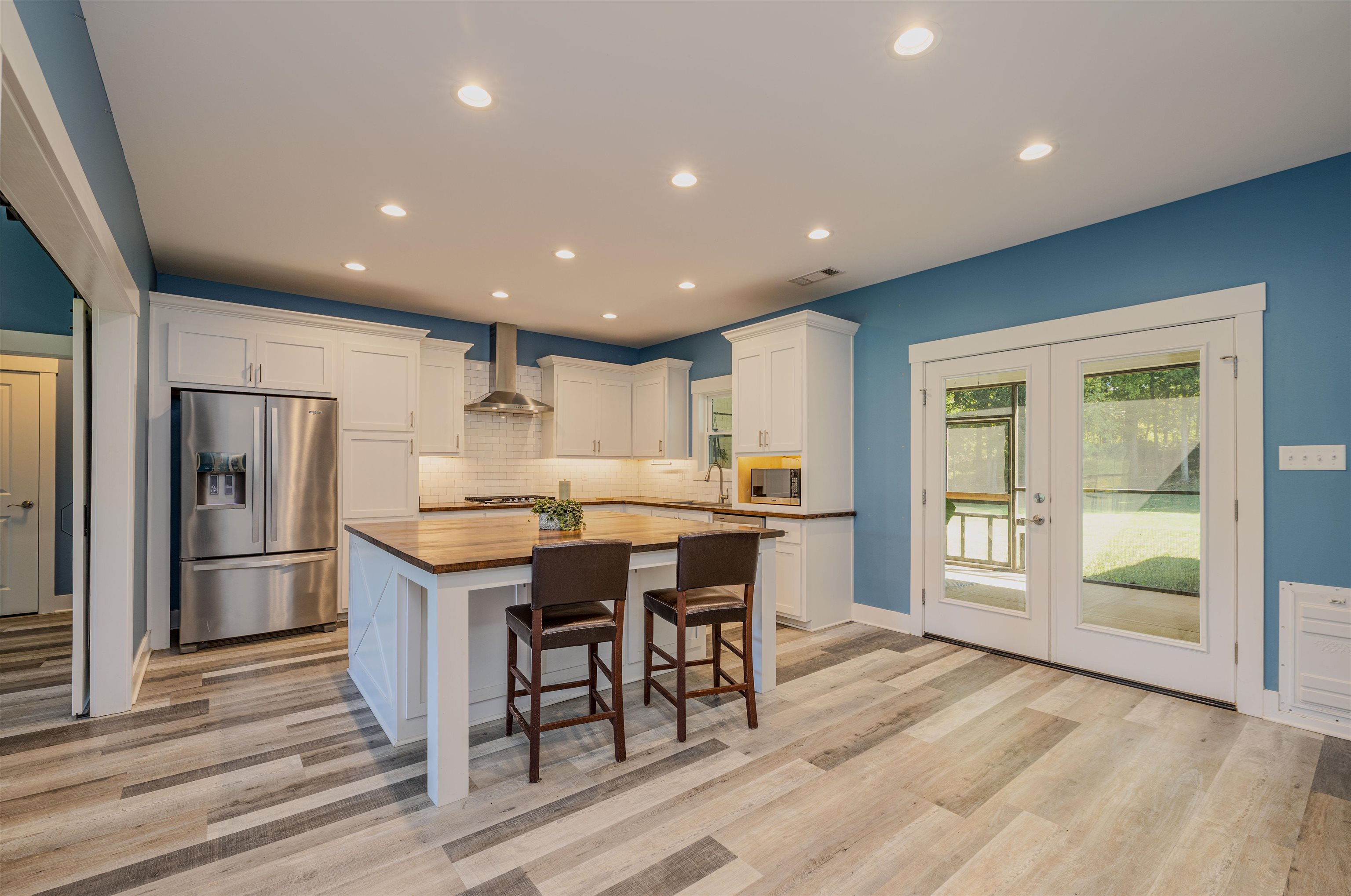 3090 Marshall Road Munford, TN 38058 - Photo 12 of 27 a kitchen with stainless steel appliances kitchen island granite countertop a refrigerator a stove a sink a dining table and chairs with wooden floor