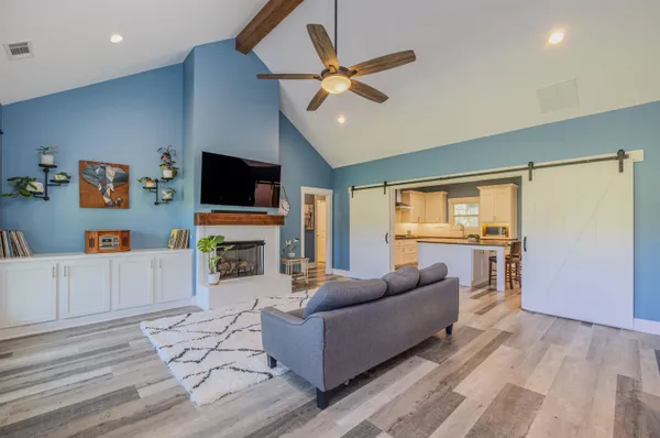 a living room with furniture a fireplace and a flat screen tv
